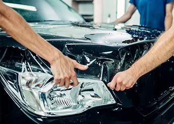 paint protection film being applied to a high end vehicle